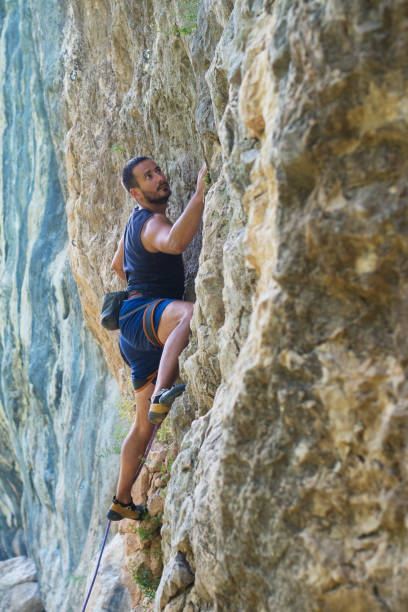 istock Rock climber with hand in chalk bag hanging on boulder 829669800