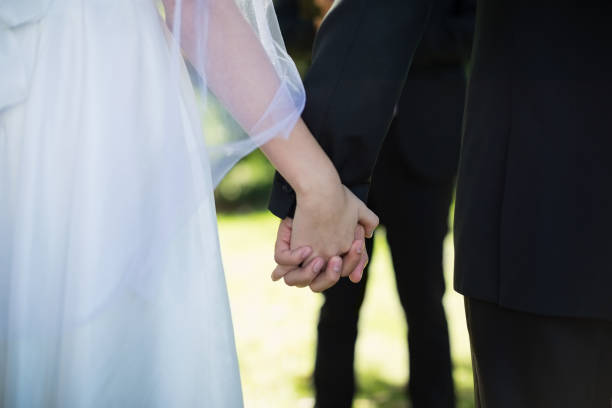 istock Mid section of couple holding hands 829673046