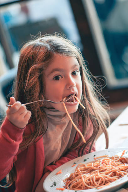 istock Cute Little Girl Eating Spaghetti 829683032