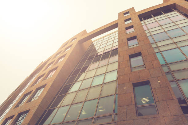 istock low angle view of office building with glass front in sunlight 829691668