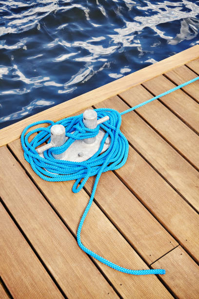 istock Cleat with blue rope on a wooden pier. 829694764