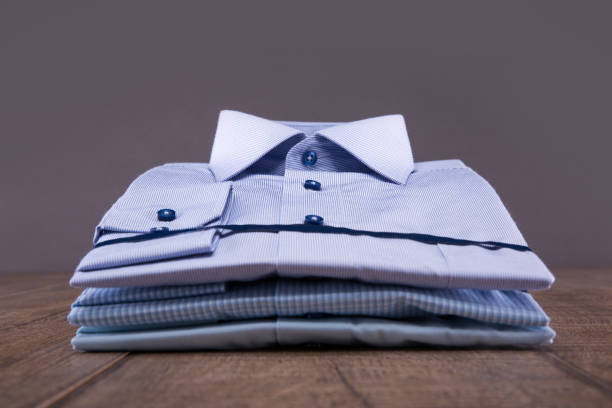 istock Men's shirts on a wooden table. Folded. The background is gray. 829698426