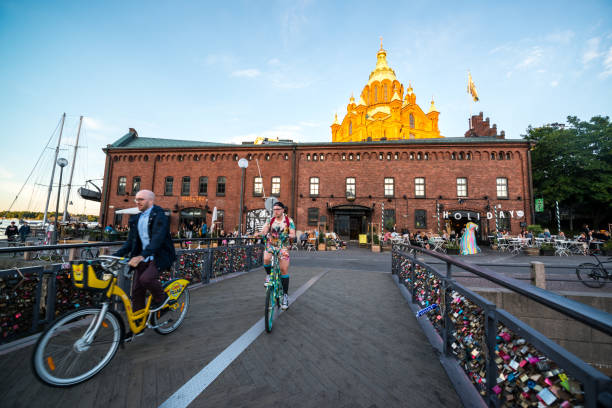 Helsinki, Finland - July 15, 2017: Tourists cycling in Helsinki, Uspenski Cathedral on background