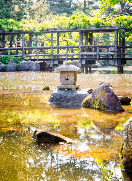 Koyasan, Japan - 5 November, 2019 Traditional japanese Garden with Red Maples, Pond and Stone Lanterns on Mount Koyasan in Japan