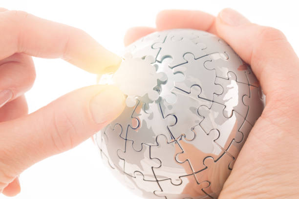 istock business concept with a hand building puzzle globe on white, space for messages 829715102