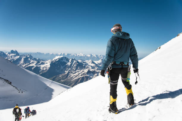 professional guide - climber on the snow-covered summit of elbrus sleeping volcano - on top of mountain peak success cold imagens e fotografias de stock