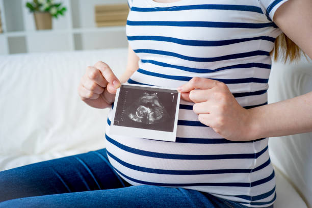 istock Pregnant woman with sonogram 829717310
