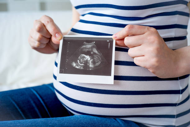 istock Pregnant woman with sonogram 829718668
