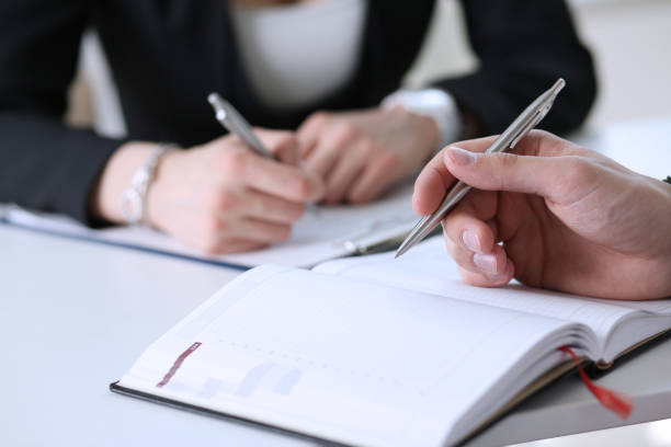 istock Group of people hold silver pen ready to make note 829728300