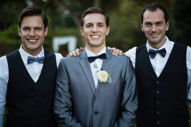 istock Smiling bridegroom and best man standing in garden 829735904