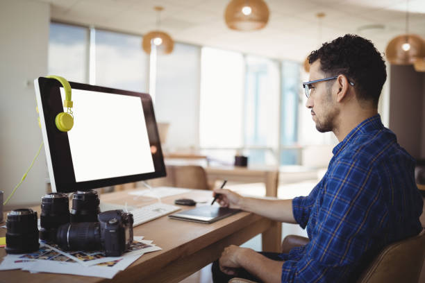 istock Attentive graphic designer using graphic tablet at desk 829745016