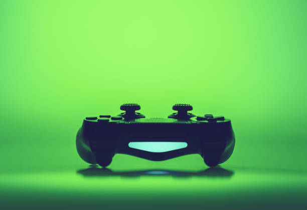 Video game joystick or controller on a vivid green graduated background with copy space viewed low angle in an eye-catching design template