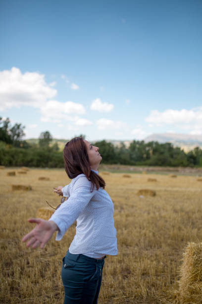 istock beautiful young woman sitting on hay. 829750192