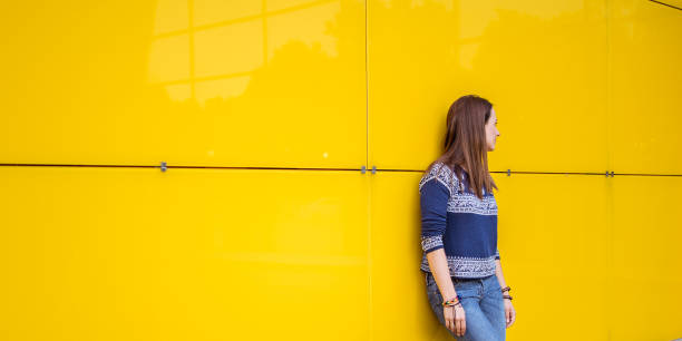 istock Woman by the yellow wall 829756674
