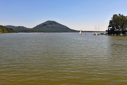 Machovo jezero, Czech republic - august 19, 2012: Machovo jezero lake with boats and Borny hill on background in summer afternoon in Machuv kraj tourist area