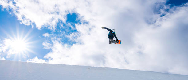 istock Male snowboarder jumping over half pipe 829762344