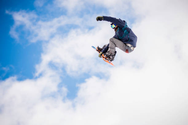 snowboarder masculino no ar - skill side view jumping mid air - fotografias e filmes do acervo