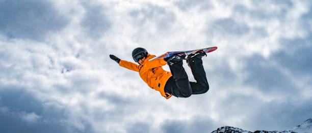 snowboarder donna a mezz'aria - skill side view jumping mid air foto e immagini stock