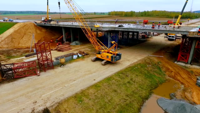 Bridge construction. Sky view of crawler crane repair bridge over highway road