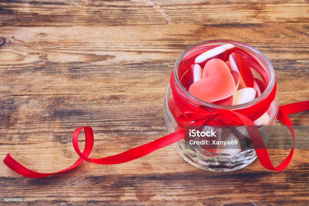 Jelly candy shape heart in glass jar Jelly candy shape heart in glass jar with ribbon for Valentine's Day, closeup Backgrounds Stock Photo