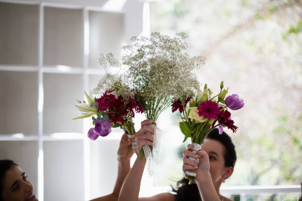 istock Bride and bridesmaids holding flower bouquet at home 829778526