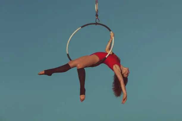 Woman is an aerial acrobat, she demonstrates the show on the hoop.