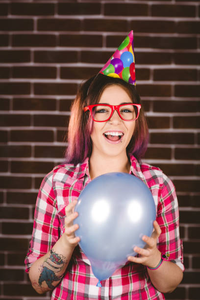 istock Beautiful woman in party hat against brick wall 829779072