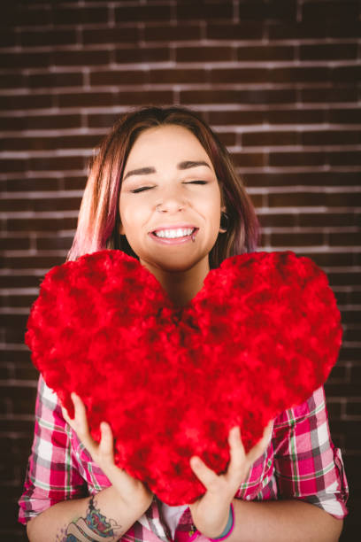istock Smiling woman holding heart shape 829781358