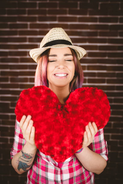 istock Smiling woman holding heart shape 829781398