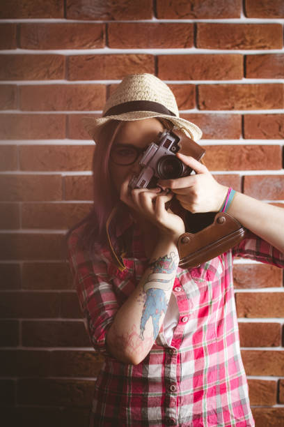 istock Woman photographing from vintage camera 829805628