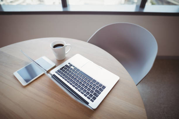 istock Cup of coffee with digital tablet and laptop on table 829811686