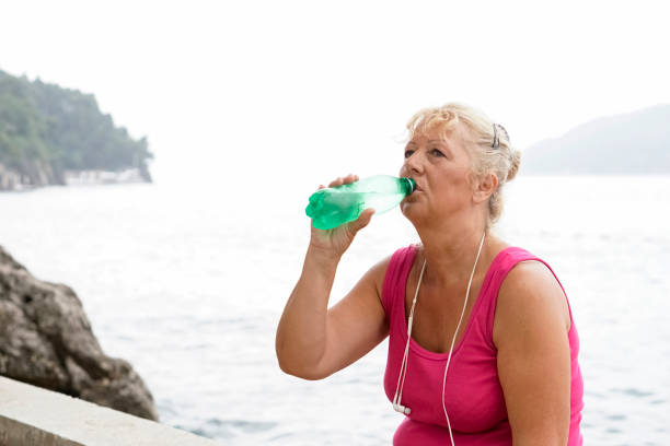 istock Mature  woman exercise outdoors by the sea 829823704