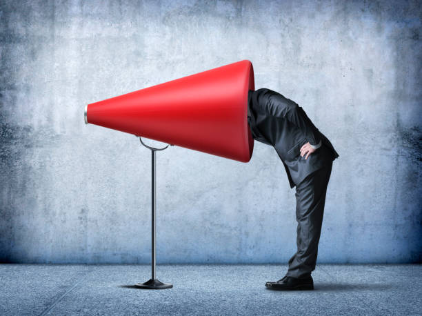 istock Businessman Sticks His Head Into A Large Red Megaphone 829845996