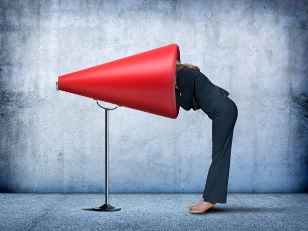 istock Businesswoman Sticks Her Head Into A Large Red Megaphone 829846016