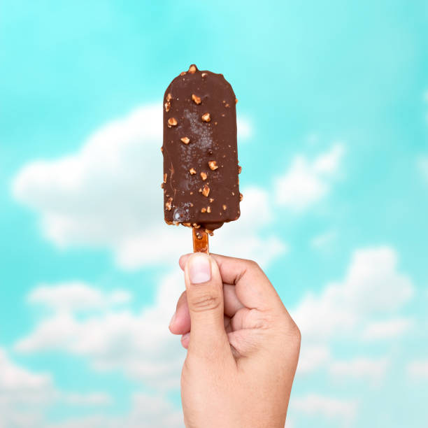 istock Hand holding chocolate ice cream on blur sky 829868390