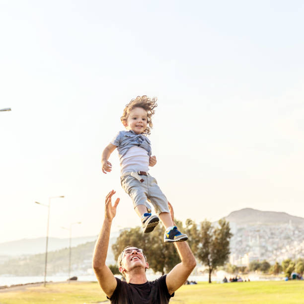 istock Father tossing son in air 829868440
