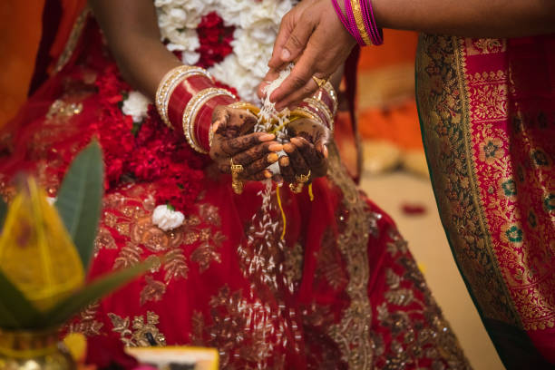 istock Indian Hindu wedding - rice being poured through bride's hands. 829892760