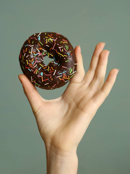 istock hand hold doughnut with chokolate glaze frosting 829898828