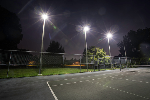 Tennis court lit up at night time