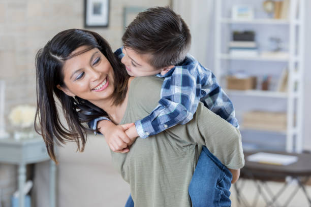 istock Playful mom carries her son on her back 829916716