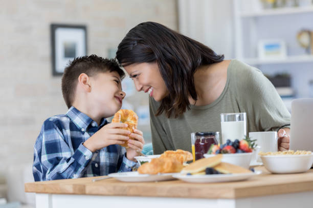 istock Little boy enjoys breakfast with his mom 829916722