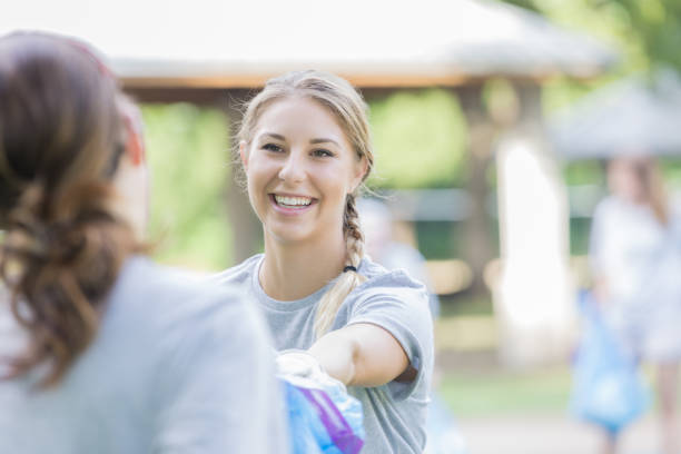 istock Community cleanup organizer hands volunteer a garbage bag 829917014