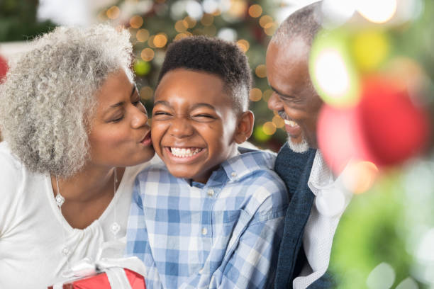 la nonna bacia suo nipote la mattina di natale - couple black american culture kissing foto e immagini stock