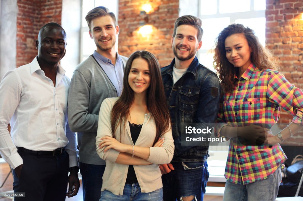 Portrait of creative business team standing together and laughing. Multiracial business people together at startup. Portrait of creative business team standing together and laughing. Multiracial business people together at startup Teamwork Stock Photo