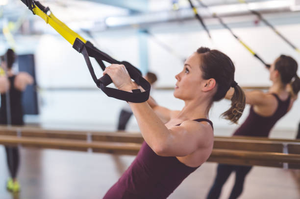 Group of Women Doing Workout Multiethnic group of young women do suspension workout together at modern gym suspension training stock pictures, royalty-free photos & images