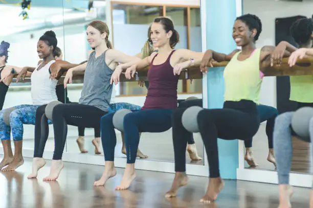 Photo of Multi-ethnic group of women doing barre workout
