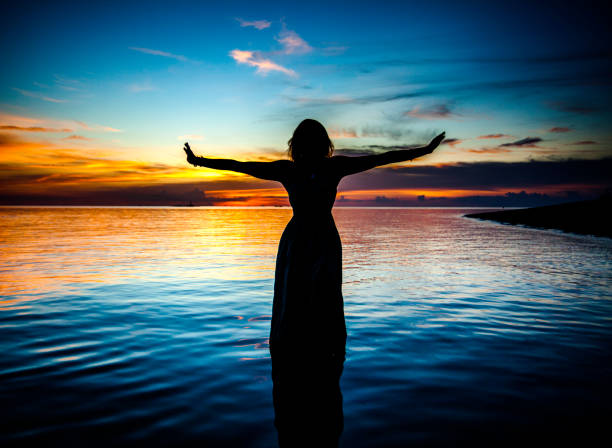 istock Woman Silhouette Dancing in Ocean Water 829967752