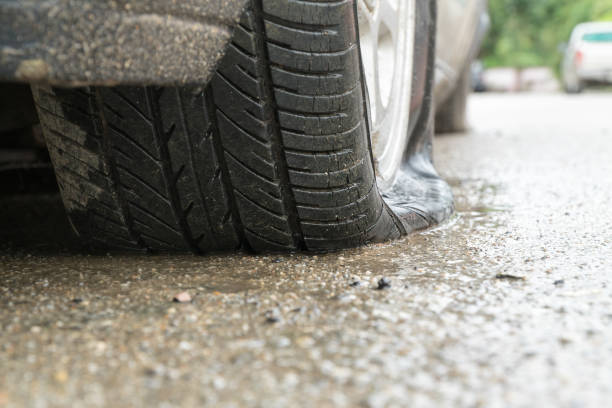 istock flat tire car in rainy day on stret. 829993456