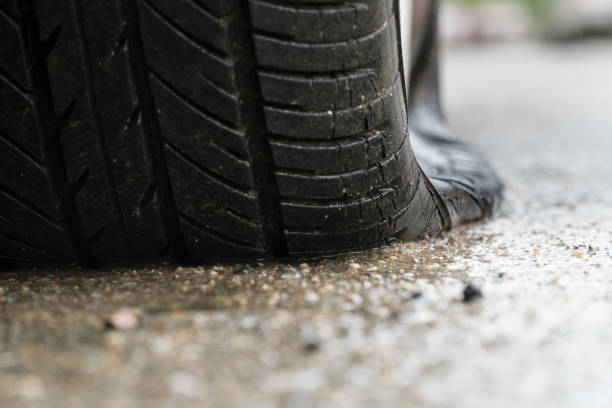 istock flat tire car in rainy day on stret. 829993790