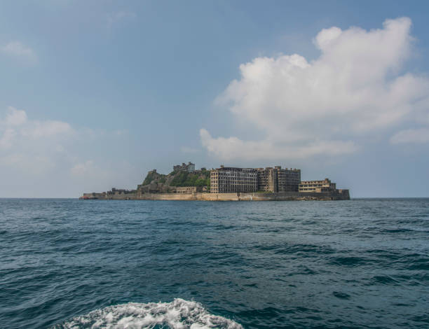 Battleship Island (Gunkanjima, Hashima, Gunkanjima, Gunkanjima, Gunkanjima) Hashima Island (端島 or simply Hashima — -shima is a Japanese suffix for island), commonly called Gunkanjima (軍艦島; meaning Battleship Island), is an abandoned island lying about 15 kilometers (9 miles) from the city of Nagasaki, in southern Japan. It is one of 505 uninhabited islands in Nagasaki Prefecture. The island's most notable features are its abandoned concrete buildings, undisturbed except by nature, and the surrounding sea wall. While the island is a symbol of the rapid industrialization of Japan, it is also a reminder of its dark history as a site of forced labor prior to and during the Second World War. mitsukejima island photos stock pictures, royalty-free photos & images